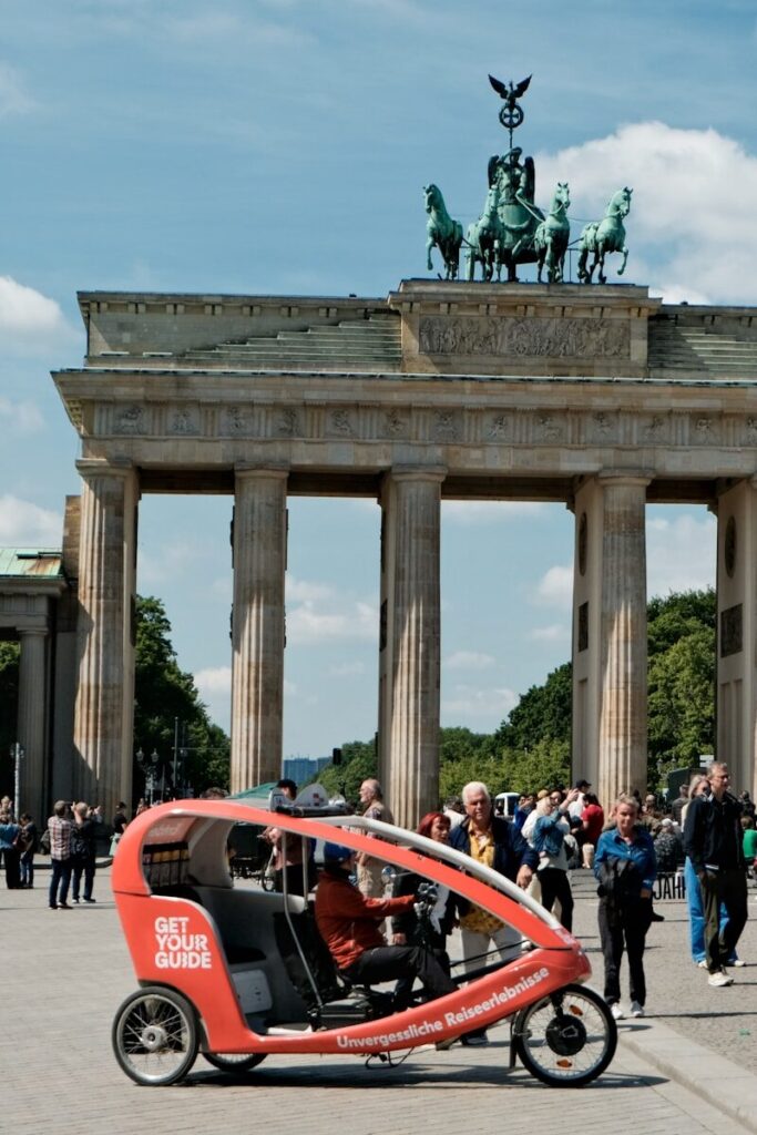 Tourists ride a pedicab near brandenburg gate in berlin.